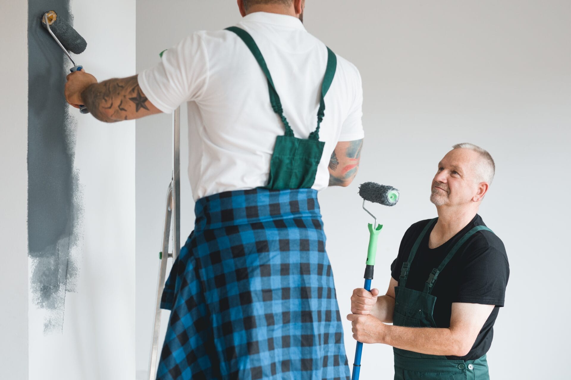 Efficient renovation crew painting white walls of new build home